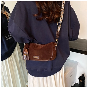 Brown suede cylinder bag with vintage ethnic strap and gold metal hardware