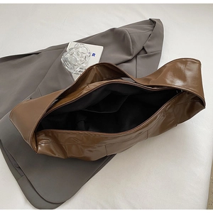 Detailed interior of a caramel brown leather tote bag with a zipper and inner pocket