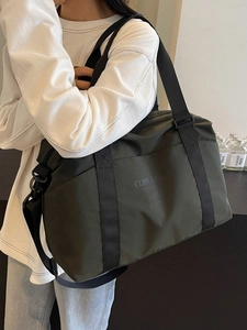 Army green large capacity travel bag with adjustable strap worn as a crossbody by model