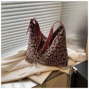 Detail of red leopard jacquard tote bag with leather strap and silver metal logo