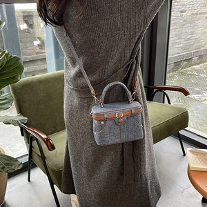 Retro denim box handbag with brown leather trim shown in a cozy lifestyle setting