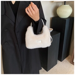 Détail du sac à main en peluche crème avec étiquette 'love every day' et texture
