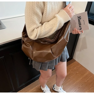 Close-up of a large dark brown pleated crossbody bag showing soft shiny PU leather texture