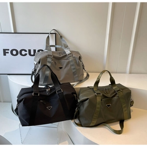 Detailed view of large travel bags in gray, black and green with metal triangle logo