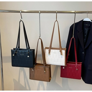 Detail showing woven texture and color options for large tote bags on hangers