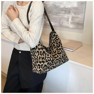 Close-up detail of leopard print tote bag showing texture and stylish black straps