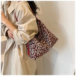 Close-up of a large tote bag featuring red and black leopard print jacquard fabric