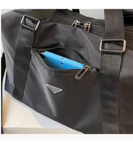 Detailed close-up of a black travel bag with a front zipper pocket holding a tablet