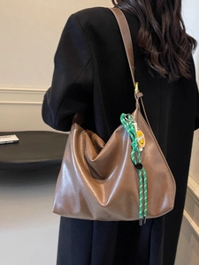 Sac fourre-tout en cuir marron avec un design souple et un pendentif smiley