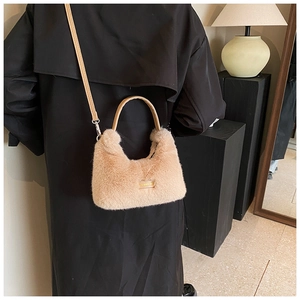 Detail of plush faux fur shoulder bag in apricot with leather handle and logo plate