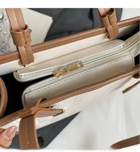 Detail of golden zipper and magnetic closure on textured beige tote bag interior