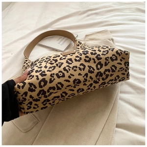 Detail of leopard print hobo bag showing canvas texture and brown leather strap