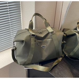 Close-up of olive green travel bag with triangle metal logo and nylon texture detail