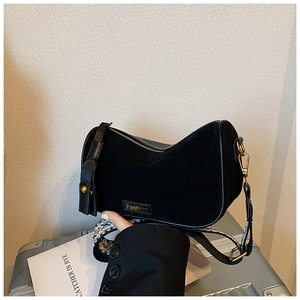 Detail of black crescent shoulder bag featuring suede texture and jacquard strap
