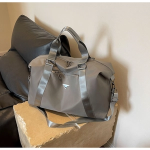 Detailed view of the large capacity travel bag on a stone base with metal logo