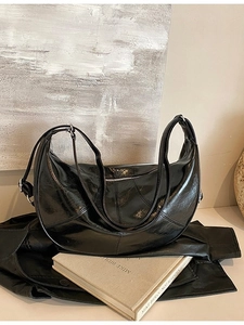 Black glossy patent leather hobo backpack with pleated design and dual shoulder straps