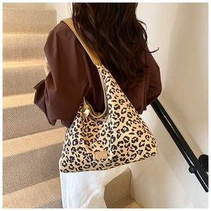 Leopard print tote bag detail with brown leather strap and decorative beads on shoulder