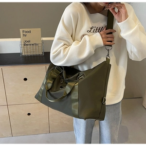 Detailed view of an olive green large capacity travel bag with reinforced shoulder straps