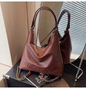 Dettaglio borsa hobo in pelle testa di moro con logo a rilievo e catena metallica oro