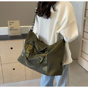 Detail of army green large travel tote with reinforced webbing handles and metal hardware