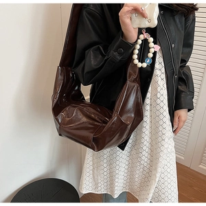 Detailed close-up of dark brown glossy pleated tote bag with premium shiny PU texture