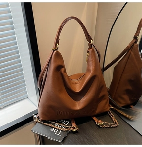 Dettaglio borsa hobo in pelle PU marrone scuro con lettere a rilievo e catena dorata