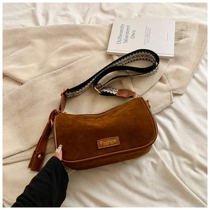 Macro shot of vintage brown suede pillow bag with a geometric pattern wide strap