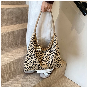 Close-up of leopard print tote bag with metallic zipper and beaded charm detail