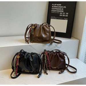 Detailed shot of retro pleated bucket bags with gold key charms in three elegant colors