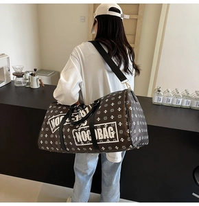 Borsa da viaggio marrone monogramma con manici in pelle in un ambiente da caffè