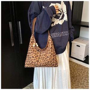 Detail of leopard print hobo bag with brown leather strap and pearl charm accent