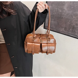 Close-up of brown retro faux leather shoulder bag with two front buckle pockets and zipper