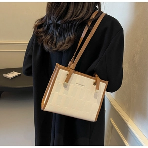Detail showing geometric woven texture and leather strap on a chic tote bag