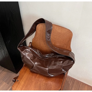 Detailed texture of brown oil wax leather hobo bag on a vintage wooden chair