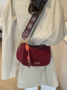 Burgundy suede pillow bag with jacquard strap and silk scarf worn with a beige coat