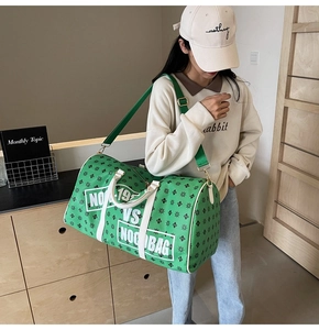 Dettaglio borsa da viaggio verde con motivo a stelle, manici e tracolla regolabile