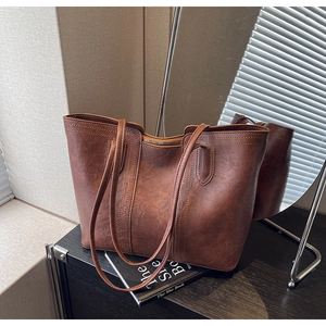 Detail of vintage brown leather tote bag showing fine stitching and retro texture