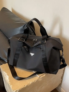 Minimalist black nylon large capacity travel bag with adjustable strap and metal plaque