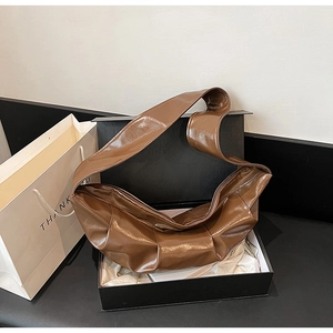 Dark brown patent leather half-moon shoulder bag in a premium black gift box packaging