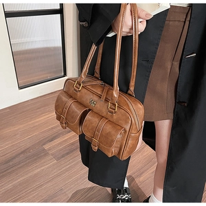 Detailed view of brown PU leather shoulder bag with double front flap pockets and gold hardware