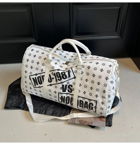 Dettaglio della borsa da viaggio in pelle bianca con motivo a stelle e testo stampato
