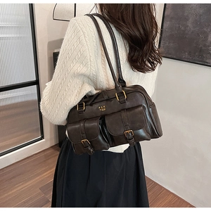 Close-up of retro dark brown underarm bag featuring dual front pockets and gold hardware