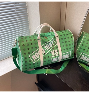 Dettaglio della borsa da viaggio verde con motivo a stelle e manici bianchi a contrasto