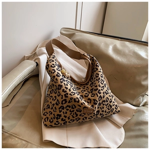 Close-up of leopard print shoulder bag with brown leather strap and side brand label