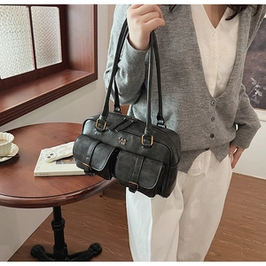 Detail of black retro leather shoulder bag with gold PAN TOR logo and dual front pockets