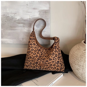 Detail of leopard print hobo bag with leather strap and MYGAOB brand patch in retro setting