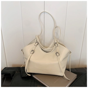 Detail of adjustable metal buckle on off-white tote bag with premium leather texture