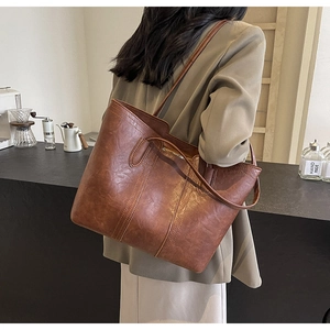 Close-up of brown vintage PU leather tote bag showing textured surface and sturdy straps