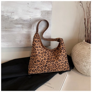 Detail of leopard print hobo bag with brown leather strap and brand label decoration