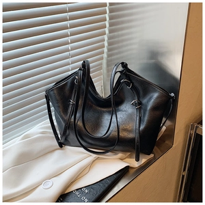 Detail of adjustable silver buckle and textured black leather on large tote bag
